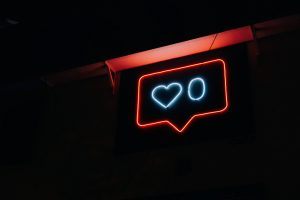 An image of a neon sign 'like' button to represent social media and how it's changed architectural design.
